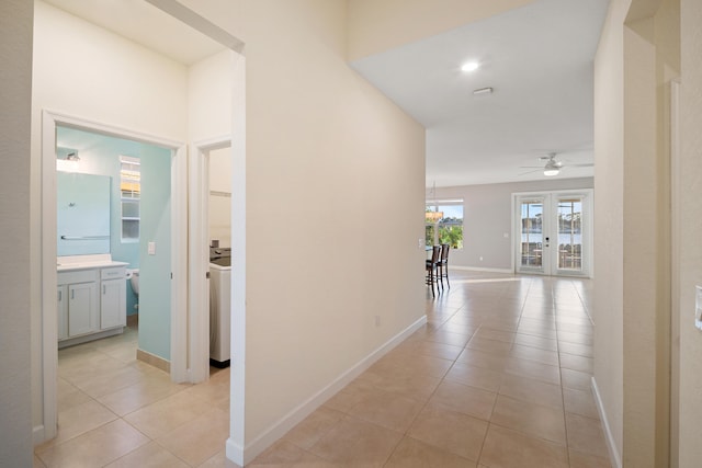 hallway featuring light tile patterned floors and an inviting chandelier