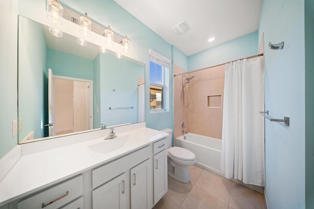 full bathroom with tile patterned floors, shower / bath combo with shower curtain, vanity, and toilet