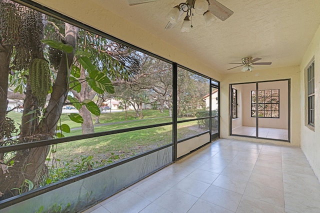 unfurnished sunroom featuring ceiling fan