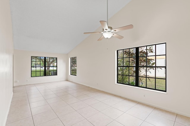 tiled spare room featuring ceiling fan, high vaulted ceiling, and a wealth of natural light