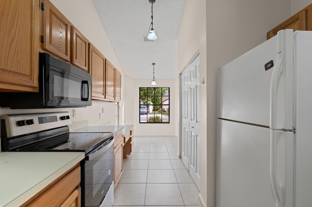 kitchen with decorative light fixtures, white fridge, light tile patterned floors, electric range, and a textured ceiling