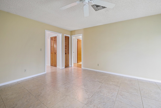 tiled spare room featuring ceiling fan and a textured ceiling