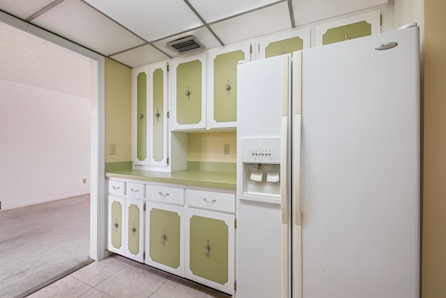 kitchen with white cabinets, light colored carpet, and white fridge with ice dispenser