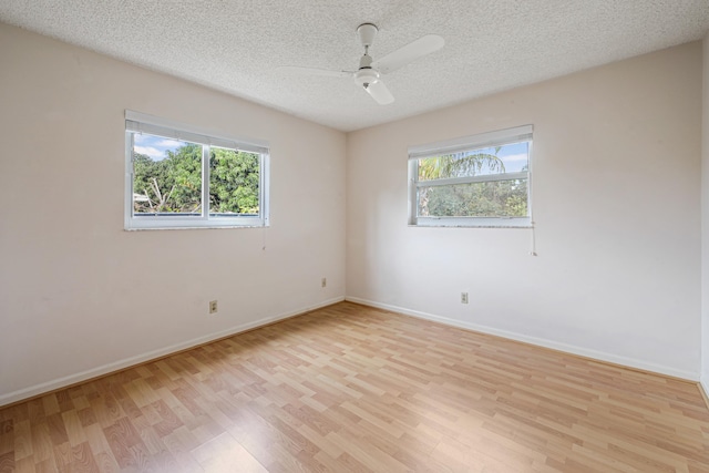 spare room with ceiling fan, a textured ceiling, and light wood-type flooring