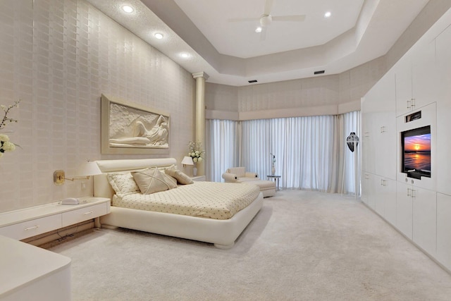 bedroom with a raised ceiling, ceiling fan, a towering ceiling, and light colored carpet