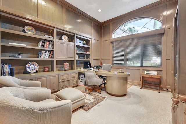 office area featuring built in desk, light colored carpet, and crown molding