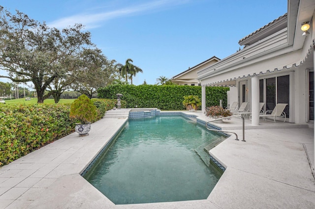 view of swimming pool featuring a patio area and an in ground hot tub