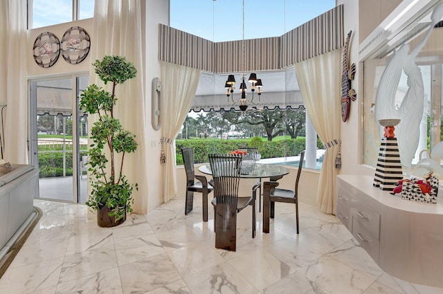 dining space with a towering ceiling and an inviting chandelier