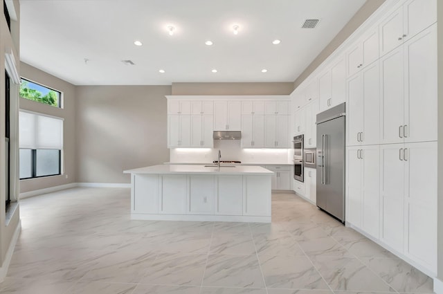 kitchen with a center island with sink, white cabinetry, and stainless steel appliances