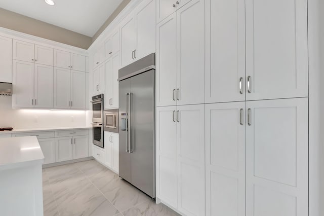 kitchen with decorative backsplash, white cabinets, and stainless steel appliances