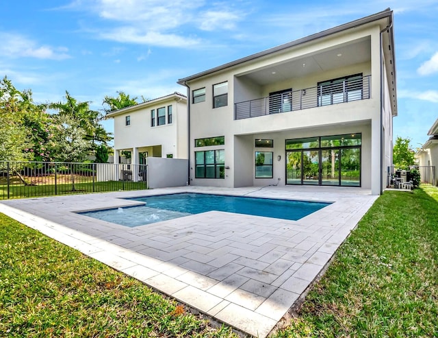 rear view of house featuring a yard, a fenced in pool, a patio area, and a balcony