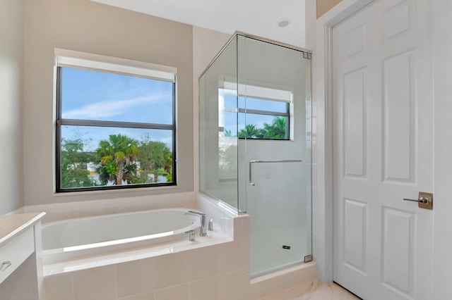 bathroom with vanity and shower with separate bathtub