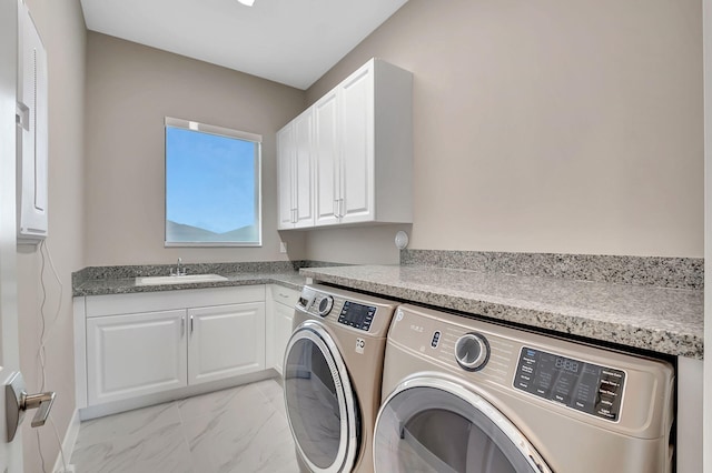 laundry room with washer and dryer, cabinets, and sink