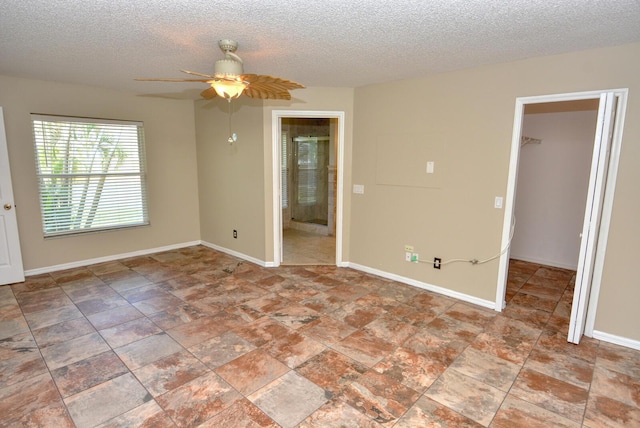 unfurnished room featuring ceiling fan and a textured ceiling