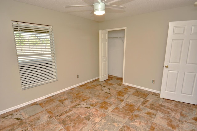 unfurnished bedroom with ceiling fan, a textured ceiling, and a closet