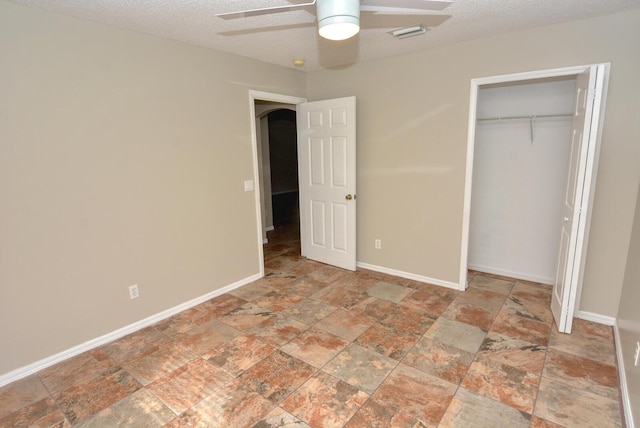 unfurnished bedroom featuring ceiling fan, a textured ceiling, and a closet