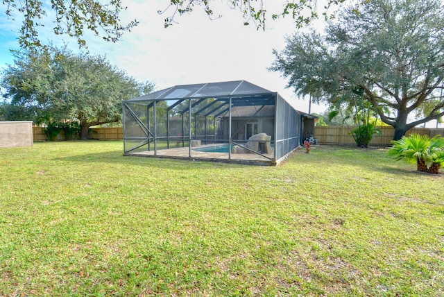 view of yard with a fenced in pool and glass enclosure