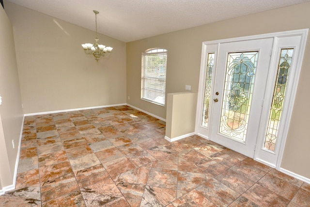 entryway featuring a chandelier and a textured ceiling