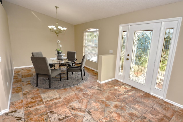 dining area featuring a chandelier and a textured ceiling