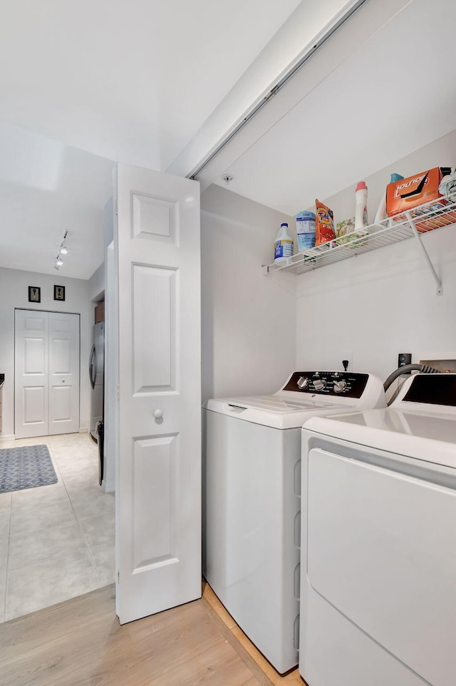 washroom with separate washer and dryer and light hardwood / wood-style floors