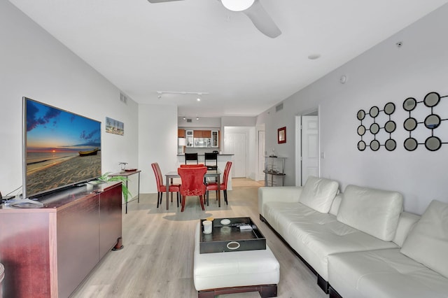 living room with ceiling fan, light wood-type flooring, and track lighting