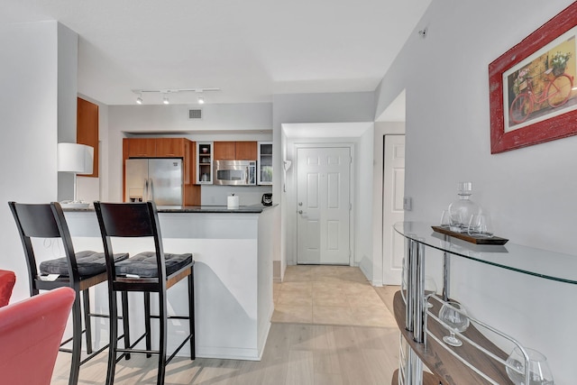 kitchen with a breakfast bar, light wood-type flooring, and appliances with stainless steel finishes