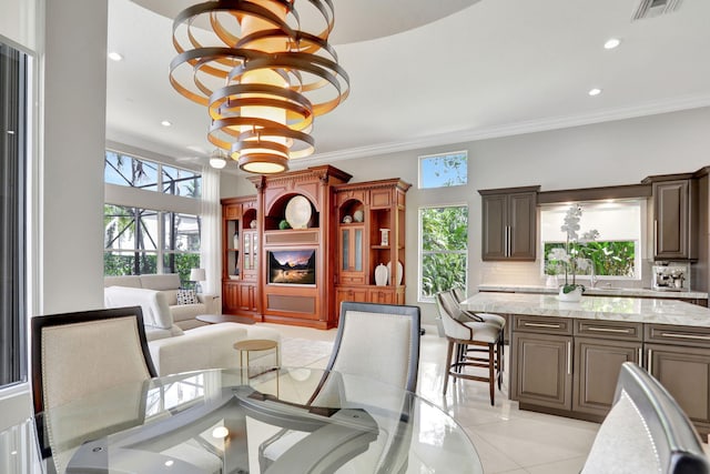 tiled dining space featuring an inviting chandelier and crown molding