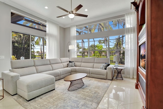 living room with ceiling fan, a towering ceiling, crown molding, and a wealth of natural light