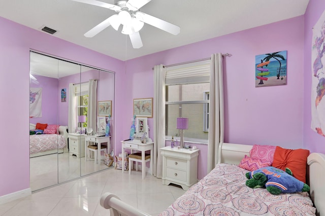 bedroom featuring ceiling fan, light tile patterned floors, and a closet