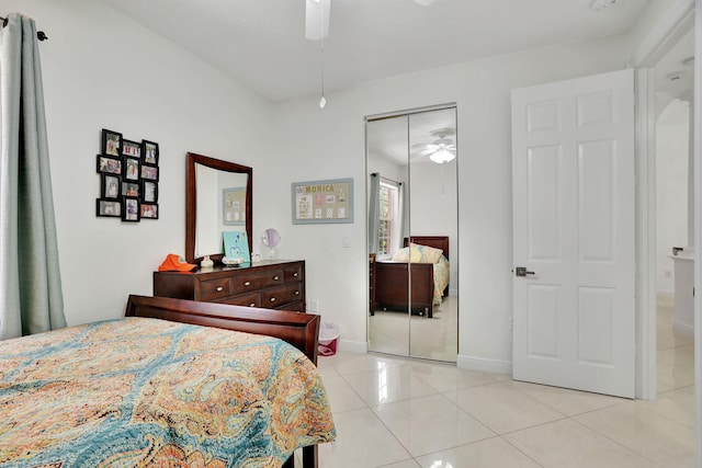 tiled bedroom featuring ceiling fan and a closet