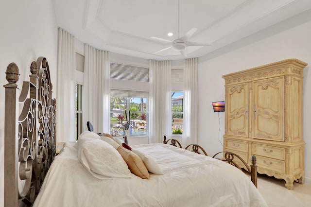 bedroom with ceiling fan and a raised ceiling