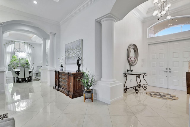 foyer entrance featuring light tile patterned floors, an inviting chandelier, and crown molding