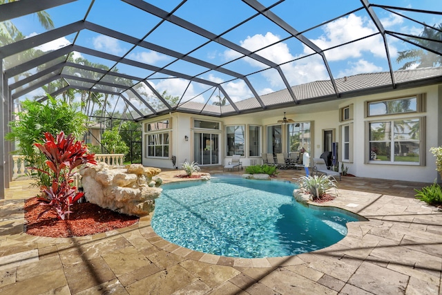 view of swimming pool featuring ceiling fan, a patio area, and a lanai