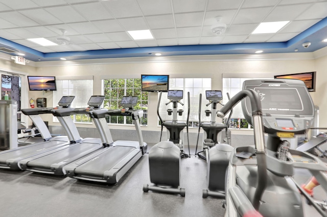 workout area featuring a paneled ceiling and ornamental molding