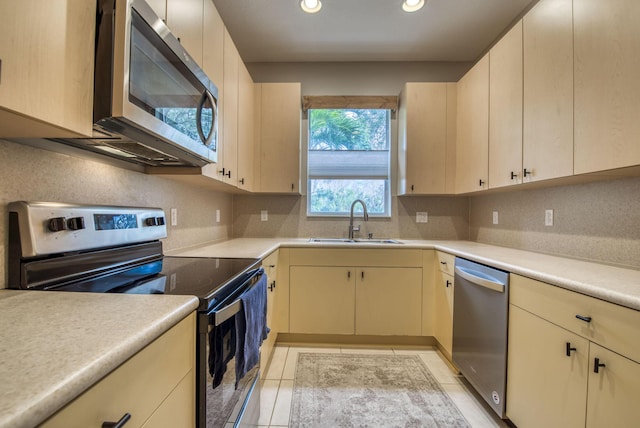 kitchen featuring appliances with stainless steel finishes, decorative backsplash, light tile patterned flooring, and sink