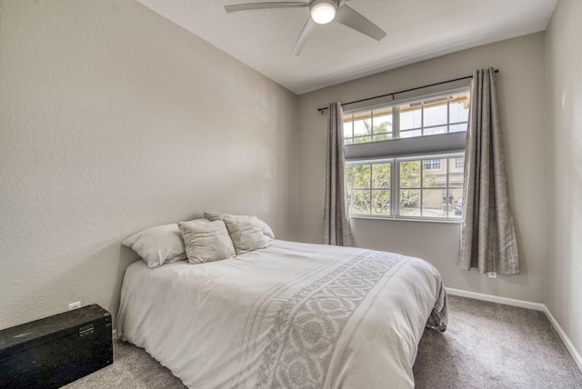 bedroom with ceiling fan, multiple windows, carpet floors, and a textured ceiling