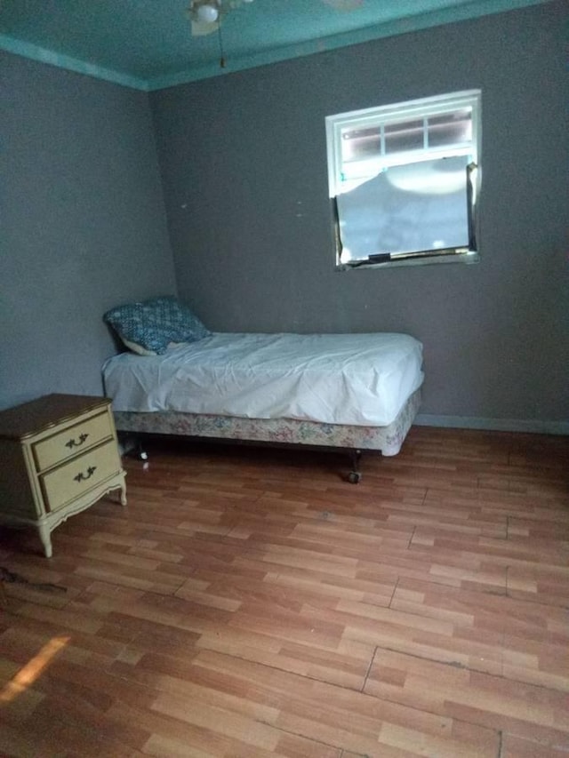 bedroom with crown molding and hardwood / wood-style flooring