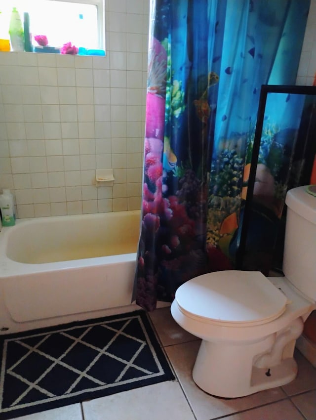 bathroom with tile patterned flooring, shower / bath combination with curtain, and toilet