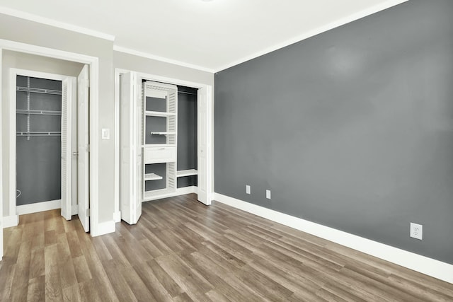 unfurnished bedroom with crown molding and hardwood / wood-style floors