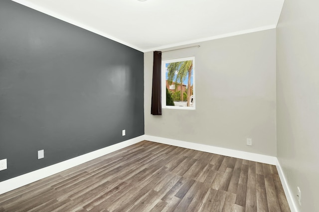 empty room featuring crown molding and hardwood / wood-style flooring