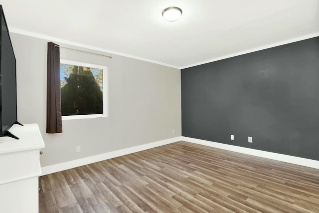 unfurnished room with light hardwood / wood-style floors and crown molding