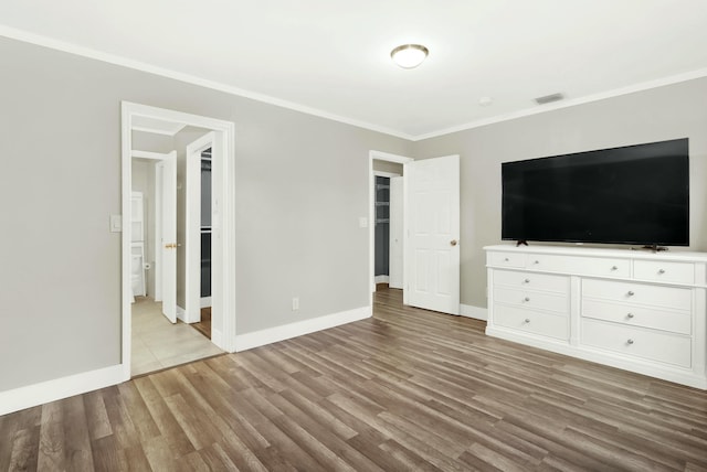 unfurnished bedroom with light hardwood / wood-style floors and crown molding