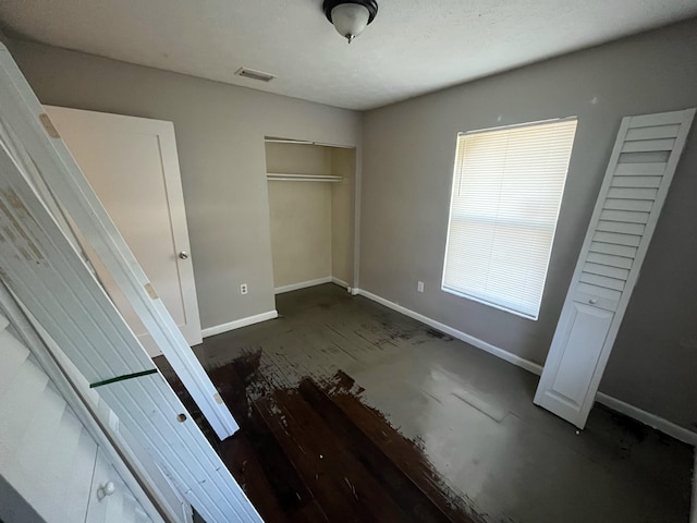 unfurnished bedroom featuring a closet and dark hardwood / wood-style floors