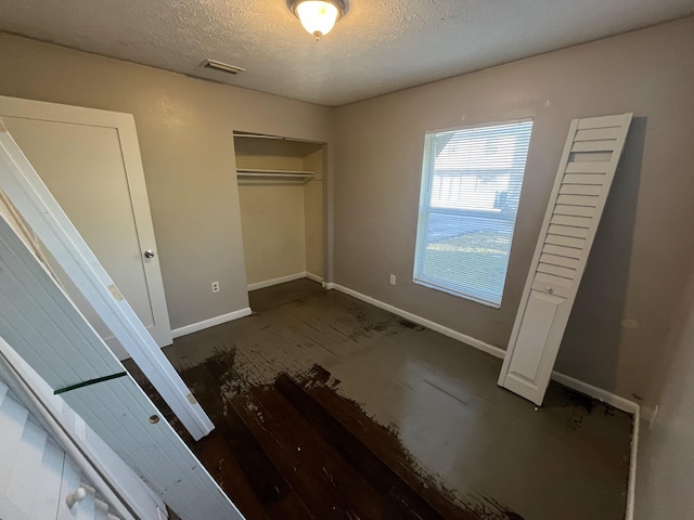 unfurnished bedroom with a textured ceiling and a closet