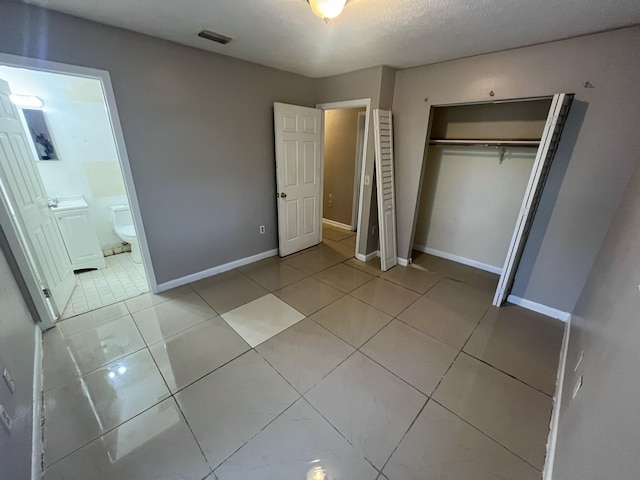 162 Booker Pl, Pahokee, FL 33476 - unfurnished bedroom featuring a closet, ensuite bath, and light tile patterned floors