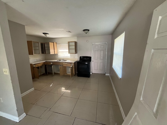 162 Booker Pl, Pahokee, FL 33476 - kitchen with black electric range oven, light countertops, light tile patterned floors, and brown cabinets