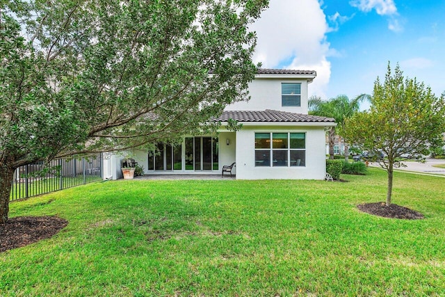 rear view of property featuring a lawn and a patio