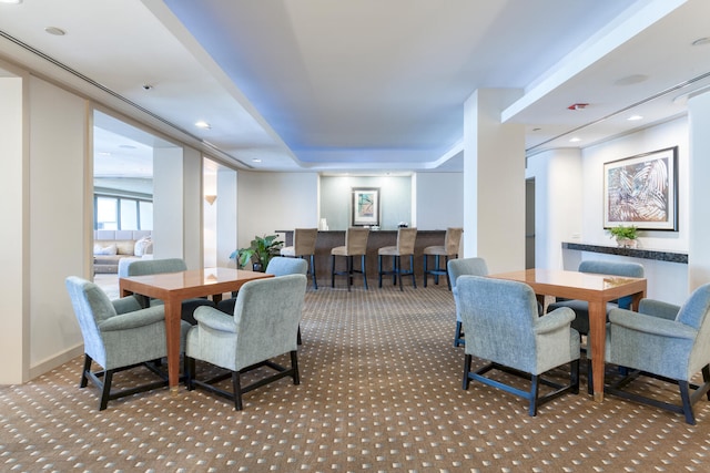 carpeted dining room featuring a raised ceiling