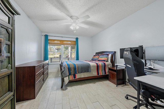 bedroom featuring ceiling fan, a textured ceiling, and light hardwood / wood-style flooring