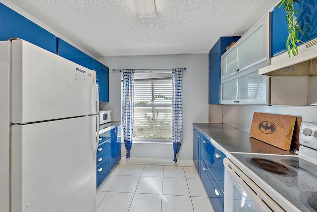 kitchen with a textured ceiling, light tile patterned floors, white appliances, and blue cabinets